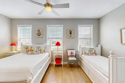a bedroom with two beds and a ceiling fan at Spacious Seabreeze Trail home with gulf views & shared pool - short walk to beach in Seacrest