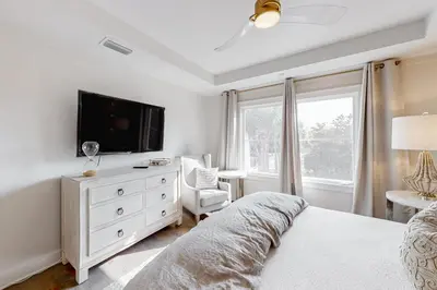 a bedroom with a bed and a tv on a dresser at Gorgeous updated condo with balconies pool & great location near 30A in Watersound Beach