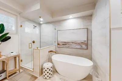 a white bathroom with a tub and a shower at Gorgeous updated condo with balconies pool & great location near 30A in Watersound Beach