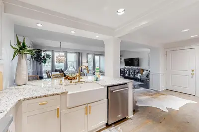 a kitchen with a sink and a living room at Gorgeous updated condo with balconies pool & great location near 30A in Watersound Beach