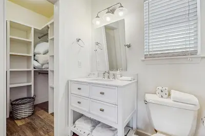 a white bathroom with a sink and a toilet at Bright coastal getaway with plenty of room and simple beach entry in Inlet Beach