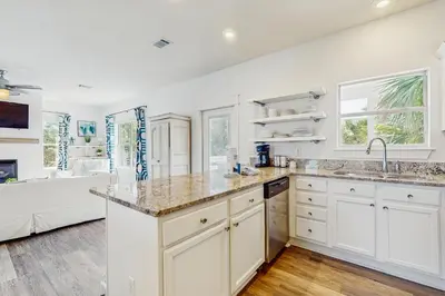 a kitchen with white cabinets and a sink and a tub at Bright coastal getaway with plenty of room and simple beach entry in Inlet Beach