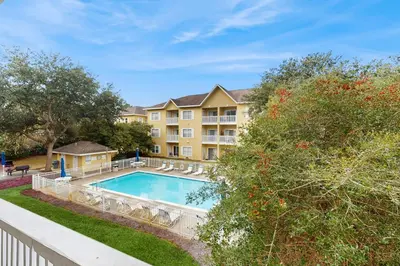 a swimming pool in front of a building at Pool-view condo with private balcony washer and dryer Wifi in Santa Rosa Beach