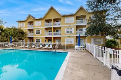 a swimming pool in front of a building with a resort at Pool-view condo with private balcony washer and dryer Wifi in Santa Rosa Beach