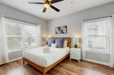 a bedroom with a white bed and two windows at Pool-view condo with private balcony washer and dryer Wifi in Santa Rosa Beach