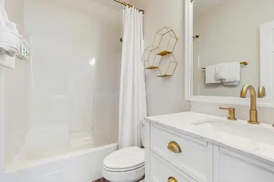 a white bathroom with a toilet and a sink at Pool-view condo with private balcony AC & washer&dryer in Santa Rosa Beach