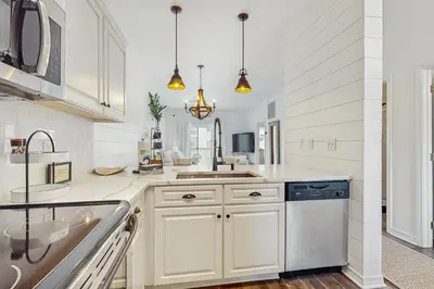 a white kitchen with a sink and a dishwasher at Pool-view condo with private balcony AC & washer&dryer in Santa Rosa Beach