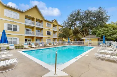a swimming pool with lounge chairs and a building at Comfortable coastal house with roomy accommodations and easy shoreline access in Santa Rosa Beach