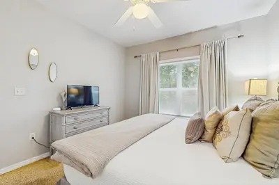 a bedroom with a bed with a television and a window at Comfortable coastal house with roomy accommodations and easy shoreline access in Santa Rosa Beach