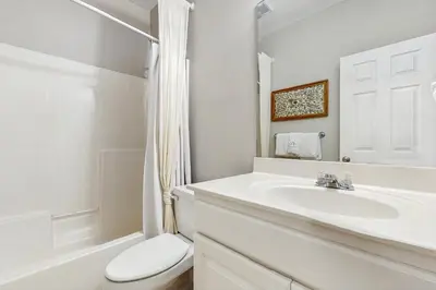 a white bathroom with a sink and a toilet at Comfortable coastal house with roomy accommodations and easy shoreline access in Santa Rosa Beach