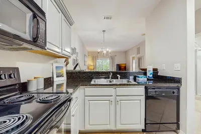 a kitchen with white cabinets and a stove top oven at Comfortable coastal house with roomy accommodations and easy shoreline access in Santa Rosa Beach