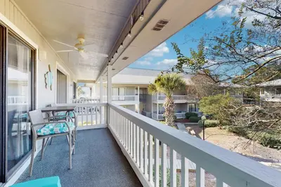 a balcony with a table and chairs on a house at Cozy coastal condo dog friendly with shared pool and close to beach in Santa Rosa Beach