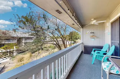 a balcony with two chairs and a view of the beach at Cozy coastal condo dog friendly with shared pool and close to beach in Santa Rosa Beach