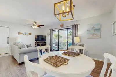 a living room with a white table and chairs at Cozy coastal condo dog friendly with shared pool and close to beach in Santa Rosa Beach