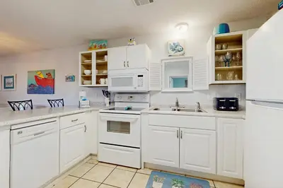 a white kitchen with white cabinets and white appliances at Cozy coastal condo dog friendly with shared pool and close to beach in Santa Rosa Beach