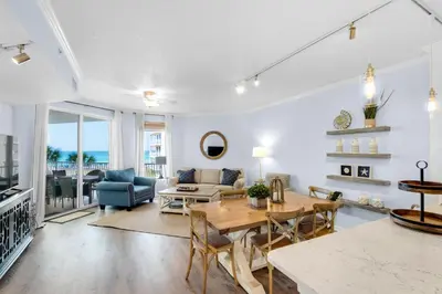 a living room with a table and a couch at Lovely waterfront condo with balcony pool hot tub & pickleball in Santa Rosa Beach