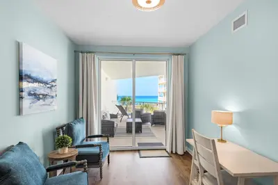 a living room with a table and chairs and a view of the ocean at Lovely waterfront condo with balcony pool hot tub & pickleball in Santa Rosa Beach