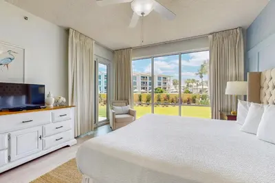 a bedroom with a large bed and a large window at Beach haven with patio lagoon pool hot tub & pickleball - walk to beach in Seacrest