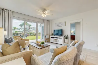 a living room with couches and a tv at Beach haven with patio lagoon pool hot tub & pickleball - walk to beach in Seacrest