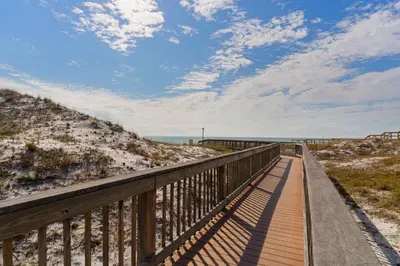 a boardwalk to the beach on a sunny day at Lovely condo with pool hot tub ocean views & pickleball in Santa Rosa Beach