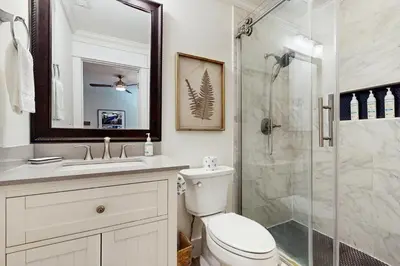 a bathroom with a toilet and a glass shower at Ideally located beachfront home with balcony washer&dryer AC & amazing views in Seacrest