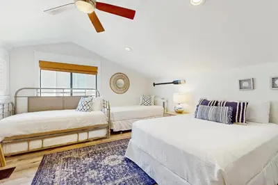a bedroom with two beds and a ceiling fan at Ideally located beachfront home with balcony washer&dryer AC & amazing views in Seacrest