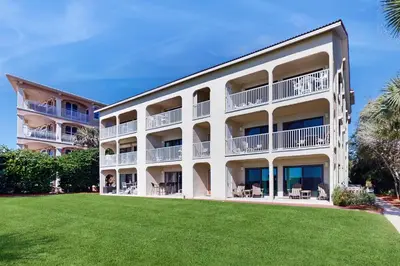 a large white building with a lawn in front of it at Ideally located beachfront home with balcony washer&dryer AC & amazing views in Seacrest
