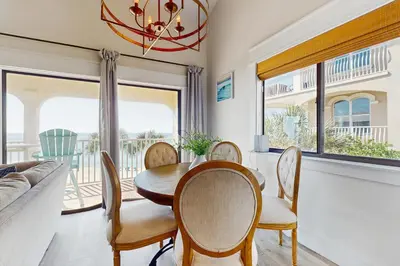 a dining room with a table and chairs and a window at Ideally located beachfront home with balcony washer&dryer AC & amazing views in Seacrest