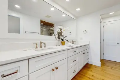 a white bathroom with two sinks and a large mirror at Lavish High Pointe condo with resort pool amazing ocean view & pickleball in Seacrest
