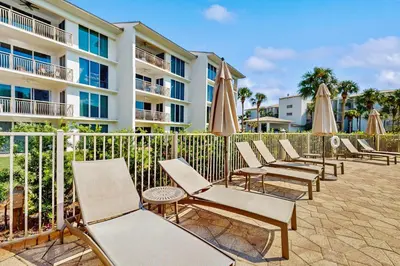 a row of chairs and umbrellas in front of a building at Lavish High Pointe condo with resort pool amazing ocean view & pickleball in Seacrest