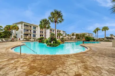 a swimming pool at a resort with palm trees at Water-view condo with pool hot tub & pickleball in Rosemary Beach