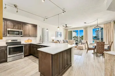 an open kitchen and living room with a dining room at Chic first-floor condo with Gulf & pool view & pickleball - steps to beach in Santa Rosa Beach