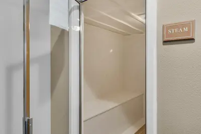 a walk in closet with a glass door at Luxe Beachfront Resort Condo with Private Beach Access & Top Amenities in Santa Rosa Beach