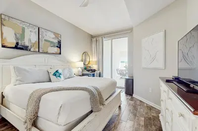 a white bedroom with a bed and a window at Luxe Beachfront Resort Condo with Private Beach Access & Top Amenities in Santa Rosa Beach