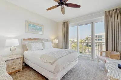 a bedroom with a bed and a large window at Gulf front condo with beach access pool hot tub tennis & pickleball in Seacrest
