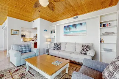 a living room with a couch and a table at Gulf front condo with beach access pool hot tub tennis & pickleball in Seacrest