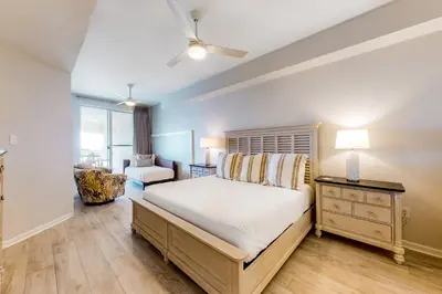 a bedroom with a large bed and a chair at Stunning 4th-floor condo with pool tennis pickleball ocean & beach view in Santa Rosa Beach