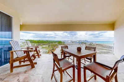 a balcony with a table and chairs and the ocean at Stunning 4th-floor condo with pool tennis pickleball ocean & beach view in Santa Rosa Beach