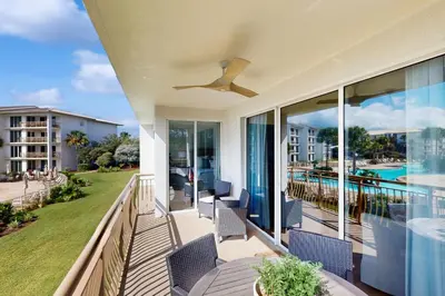 a balcony with chairs and a ceiling fan at 2nd-floor condo with beach access pool tennis pickleball hot tub balcony in Seacrest
