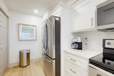 a kitchen with white cabinets and a stainless steel refrigerator at 2nd-floor condo with beach access pool tennis pickleball hot tub balcony in Seacrest