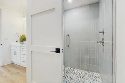 a shower with a glass door in a bathroom at Luxuriously renovated condo with Gulf views beach access pool & hot tub in Inlet Beach