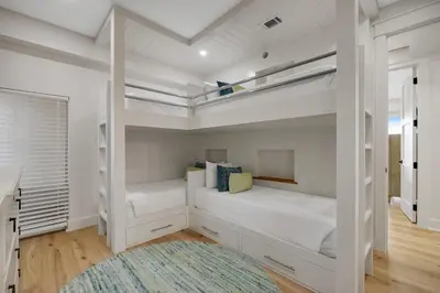 a bedroom with two bunk beds and a rug at Luxuriously renovated condo with Gulf views beach access pool & hot tub in Inlet Beach