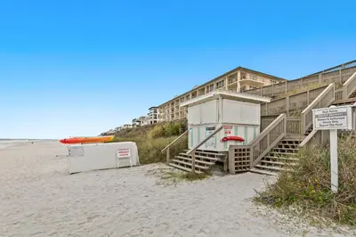 a building on the beach next to a beach at Luxuriously renovated condo with Gulf views beach access pool & hot tub in Inlet Beach