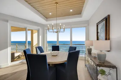 a dining room with a table and chairs and the ocean at Luxuriously renovated condo with Gulf views beach access pool & hot tub in Inlet Beach