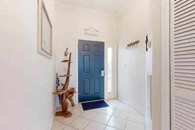 a hallway with a blue door in a house at Beach-view condo with outdoor pool hot tub sauna tennis BBQ & beach access in Santa Rosa Beach