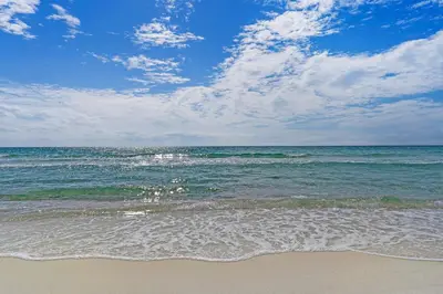 a beach with the ocean and a cloudy sky at Beach-view condo with outdoor pool hot tub sauna tennis BBQ & beach access in Santa Rosa Beach