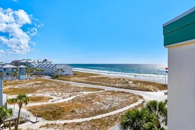 a view of the beach from the balcony of a condo at COMPLETELY UPDATED with beach access pool hot tub tennis pickleball & gym in Santa Rosa Beach