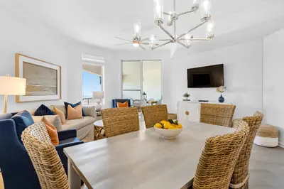 a dining room and living room with a table and chairs at COMPLETELY UPDATED with beach access pool hot tub tennis pickleball & gym in Santa Rosa Beach