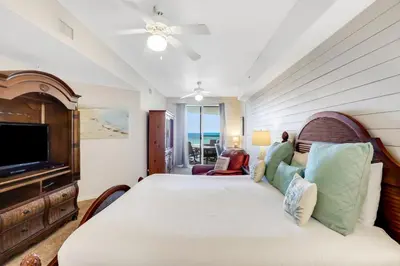 a bedroom with a bed and a flat screen tv at Oceanfront condo with pool hot tub sauna gym bikes tennis - lovely balcony in Santa Rosa Beach