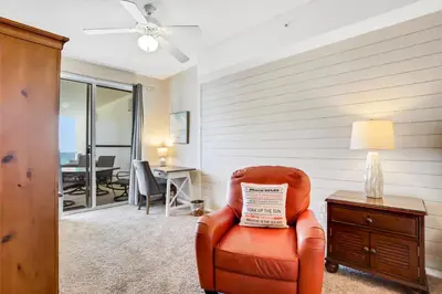 a living room with a chair and a table at Oceanfront condo with pool hot tub sauna gym bikes tennis - lovely balcony in Santa Rosa Beach